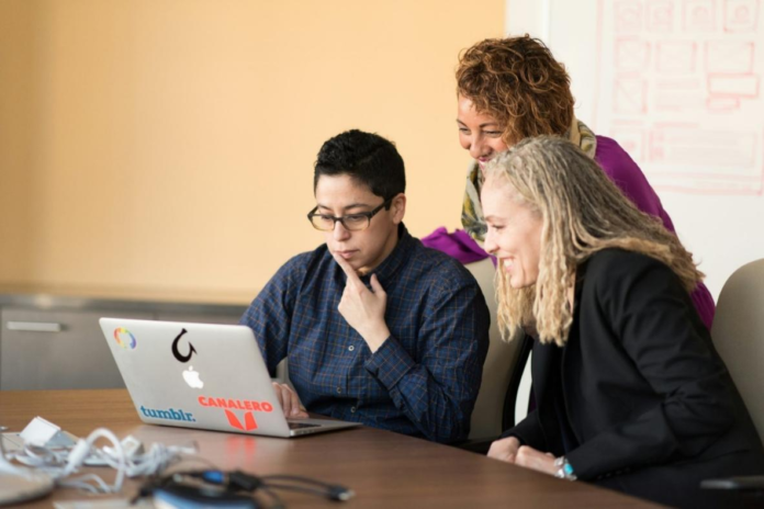 three women looking at a laptop screen